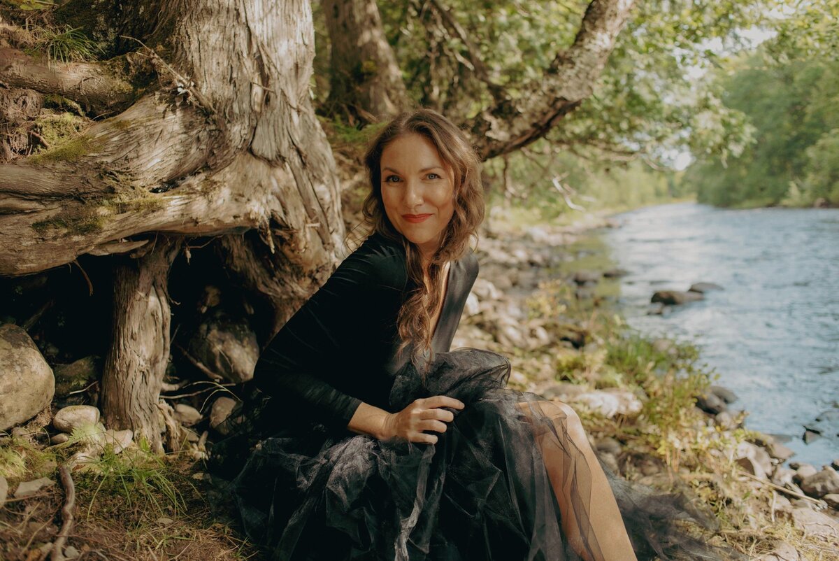 elizabeth in black dress by creek