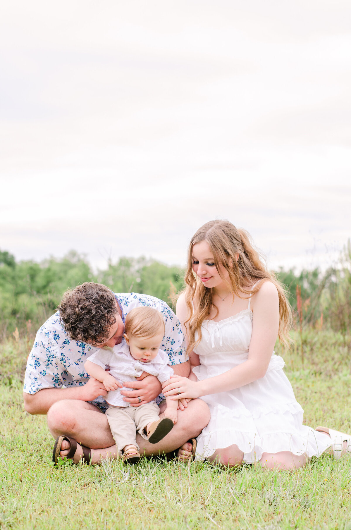 family sits on the ground in an amsterdam field