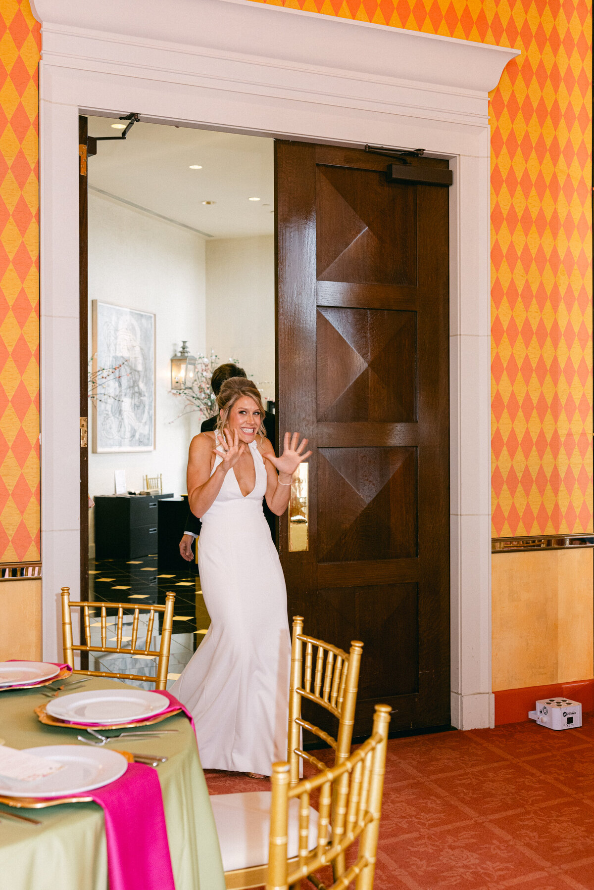 A wedding photo of the bride and groom seeing their reception area for the first time with a pink color theme
