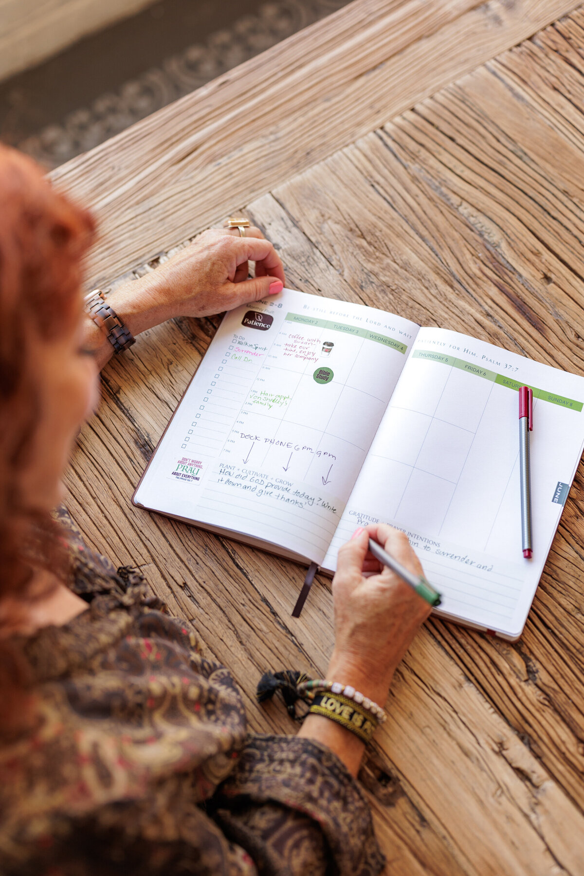 Women sitting at table writing in planner
