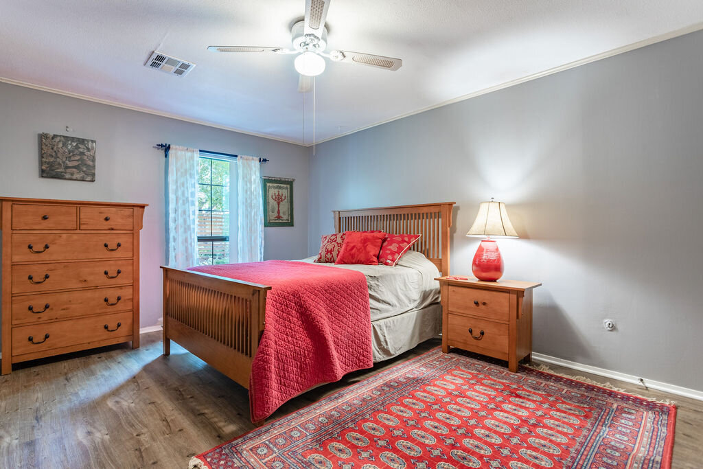 Bedroom with comfortable bedding and large dresser in this 5-bedroom, 4-bathroom vacation rental house for 16+ guests with pool, free wifi, guesthouse and game room just 20 minutes away from downtown Waco, TX.