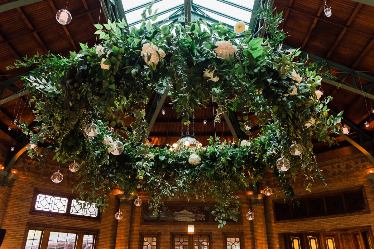 A dramatic floral ceiling installation adding romance and elegance to a wedding reception at Café Brauer.
