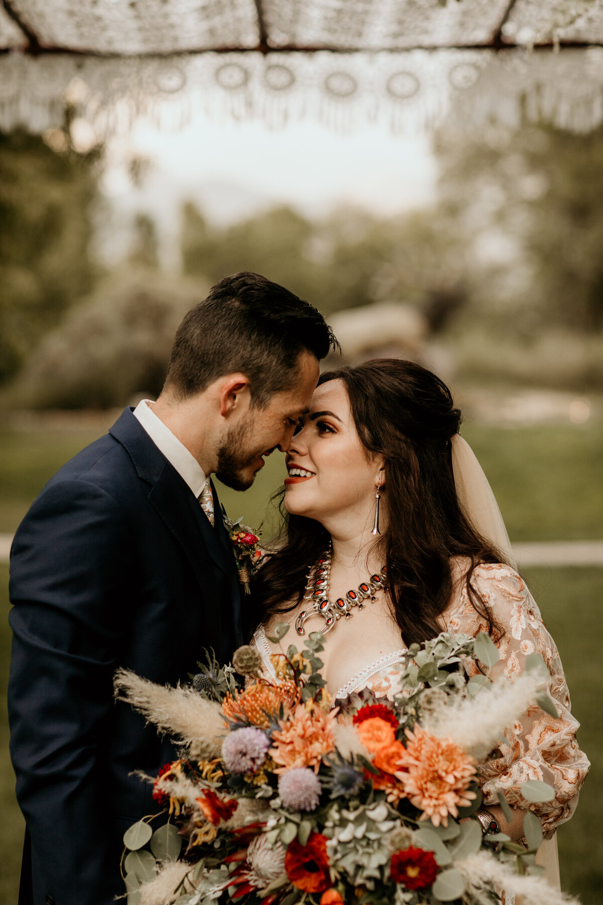 bride and groom smiling at each other with foreheads together