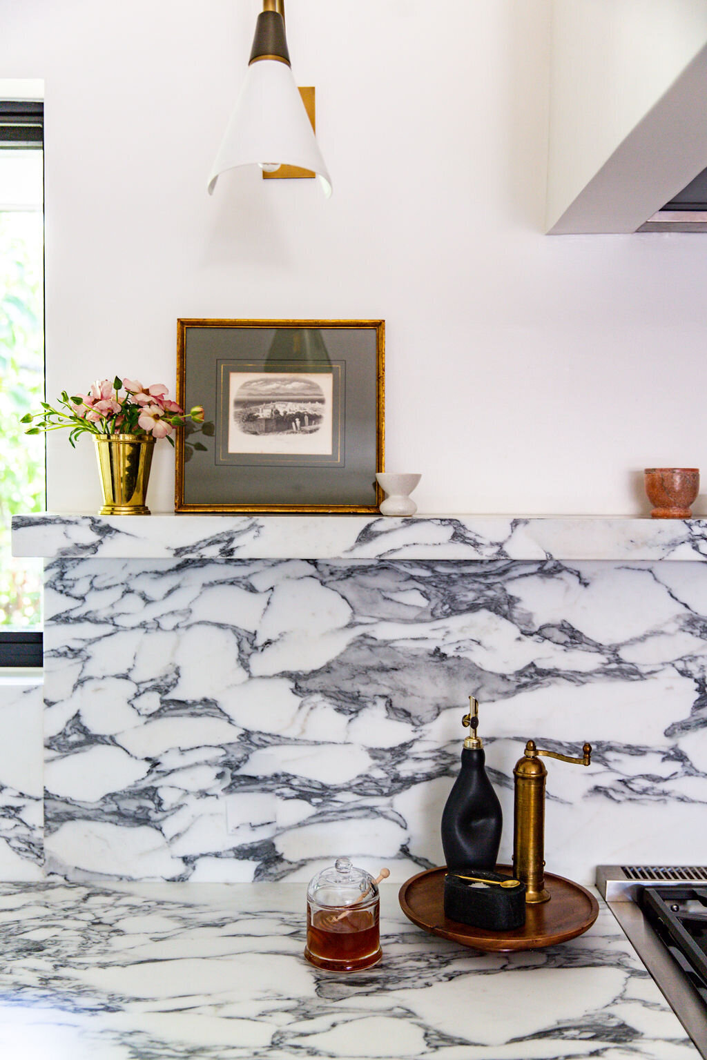 Kitchen with Corchia marble countertops, backsplash, and shelf