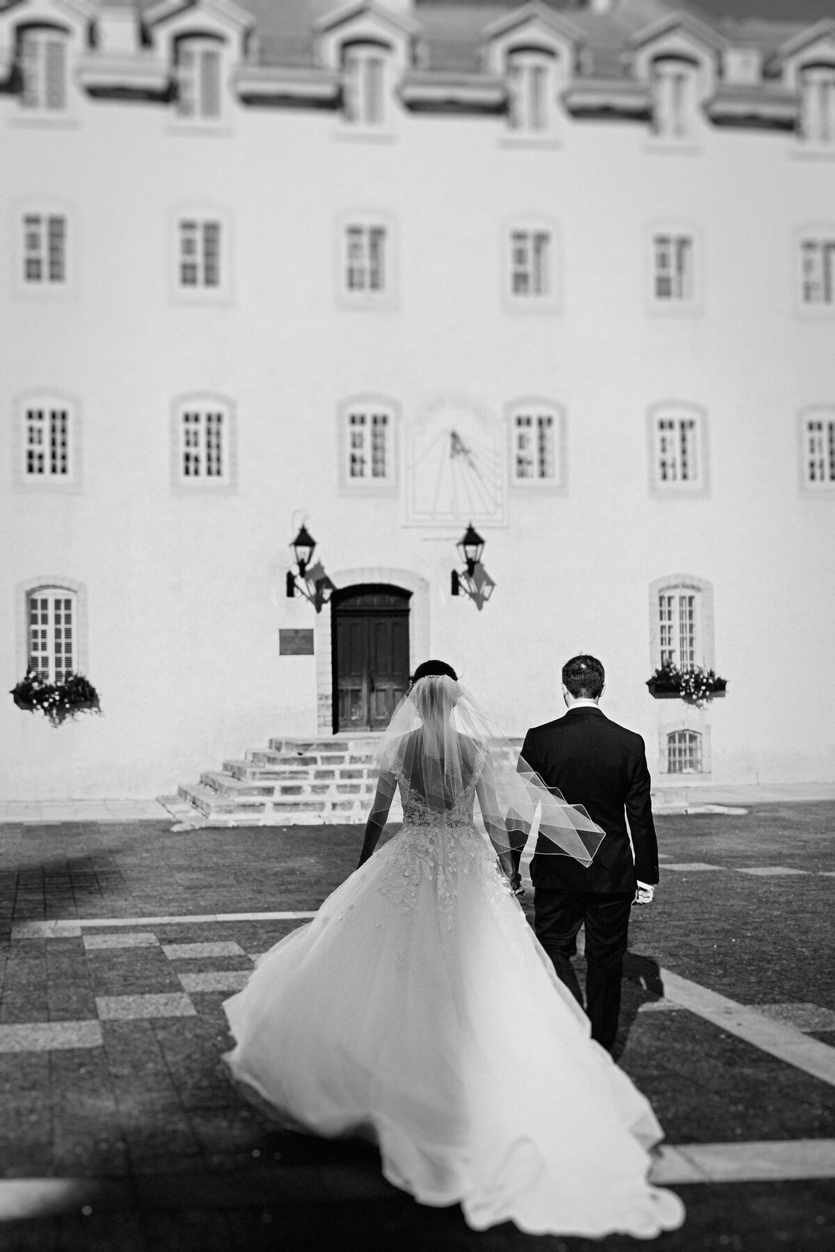 black-and-white-image-of-newlyweds-walking-in-the-courtyard-of the-seminary-in-old-quebec-city