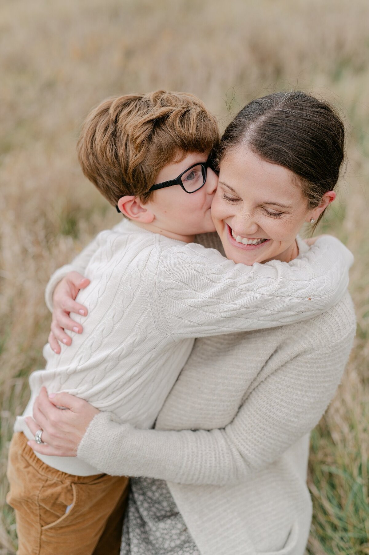 Mom and on embracing during Milwaukee family photo session, with boy kissing his mom's cheek