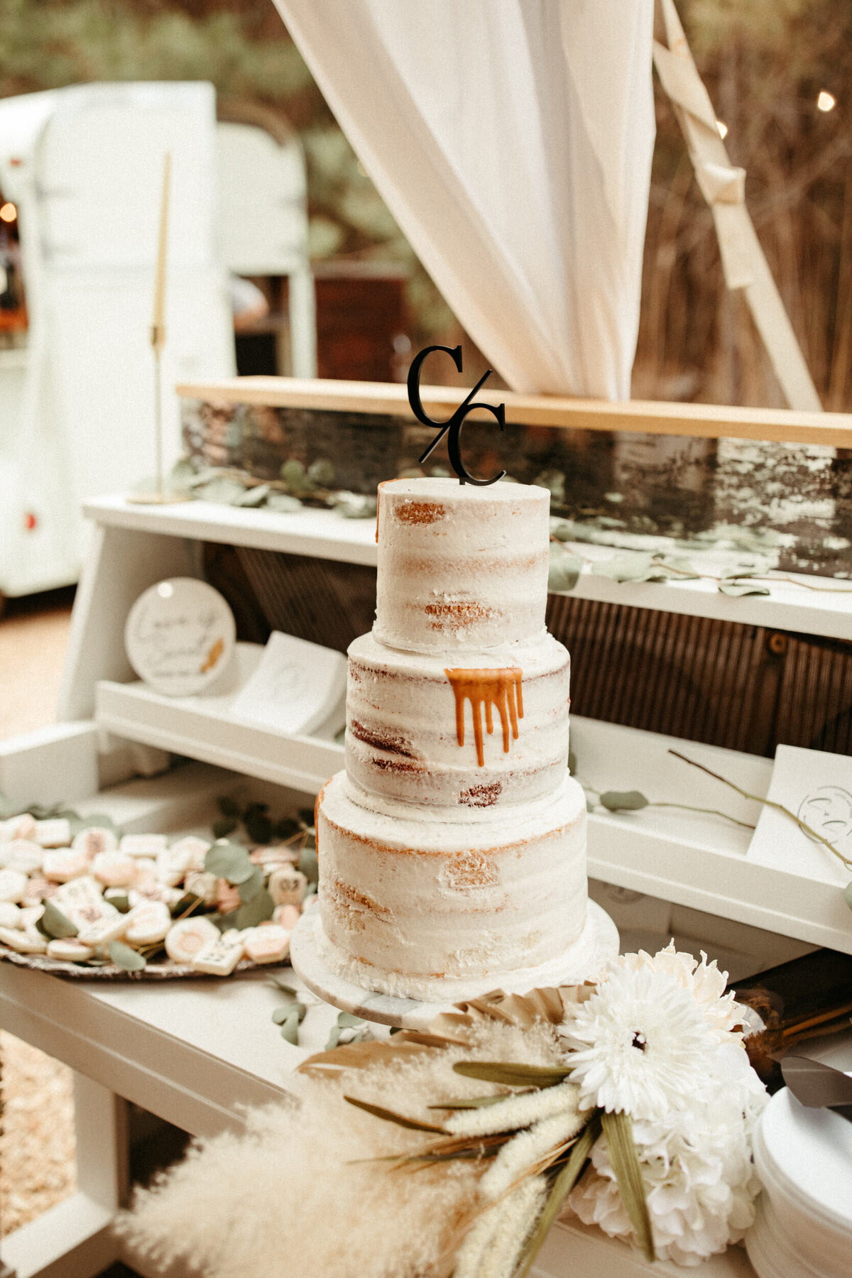 Simple three tier naked wedding cake with elegant topper