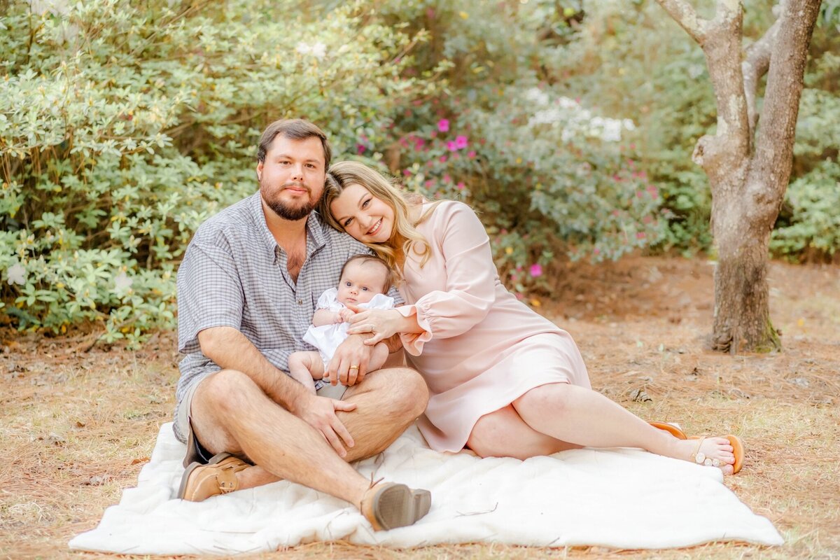 new parents sitting on a blanket  with their baby girl at georgia southern university's sweetheart circle in statesboro ga
