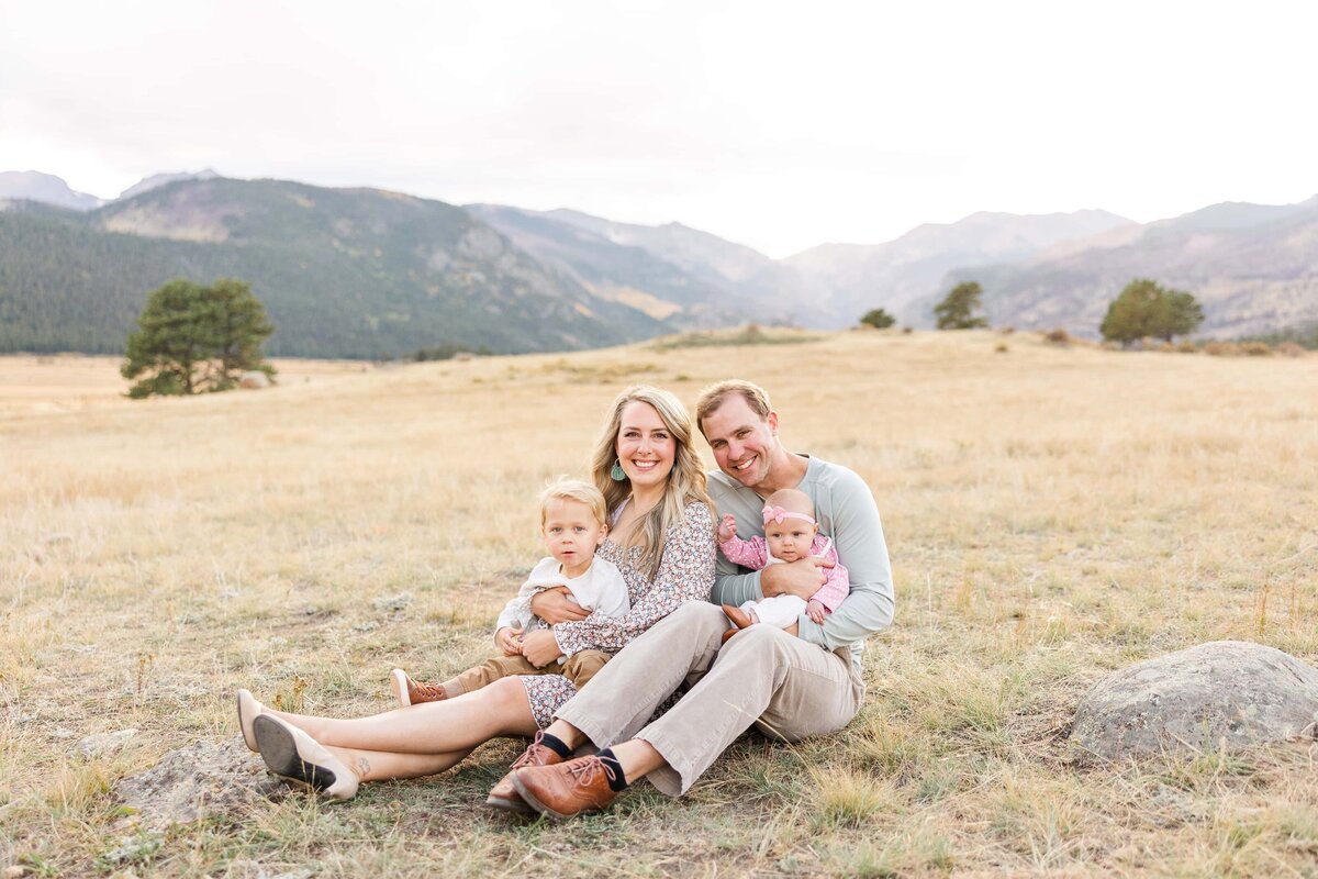 Family sitting with the Rocky Mountains as the backdrop