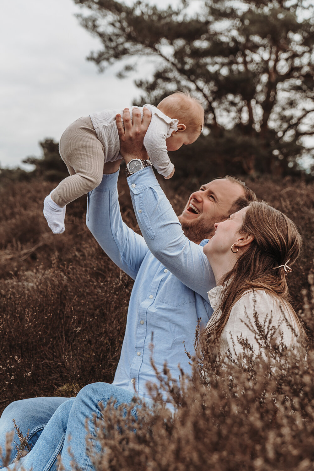 Gezin lacht en speelt met baby dochter