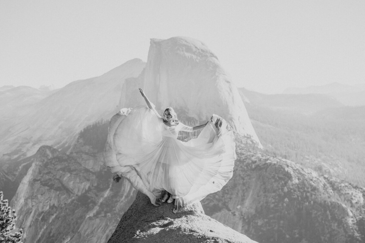 black and white of bride at glacier point with dress