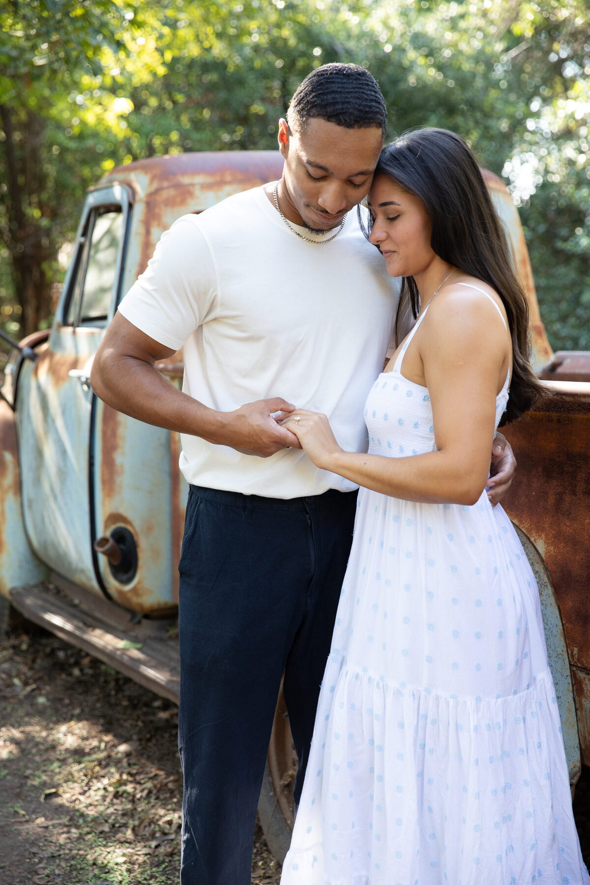 An engaged couple standing in front of an old truck, captured by an Austin wedding photographer.