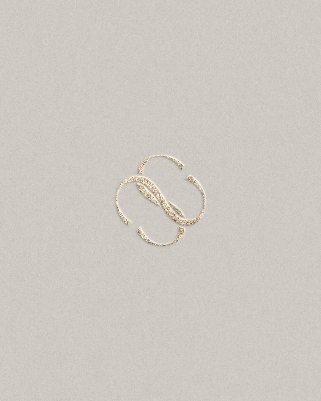 Elegant monogram logo design with intertwined gold initials on neutral background, showcasing timeless branding.