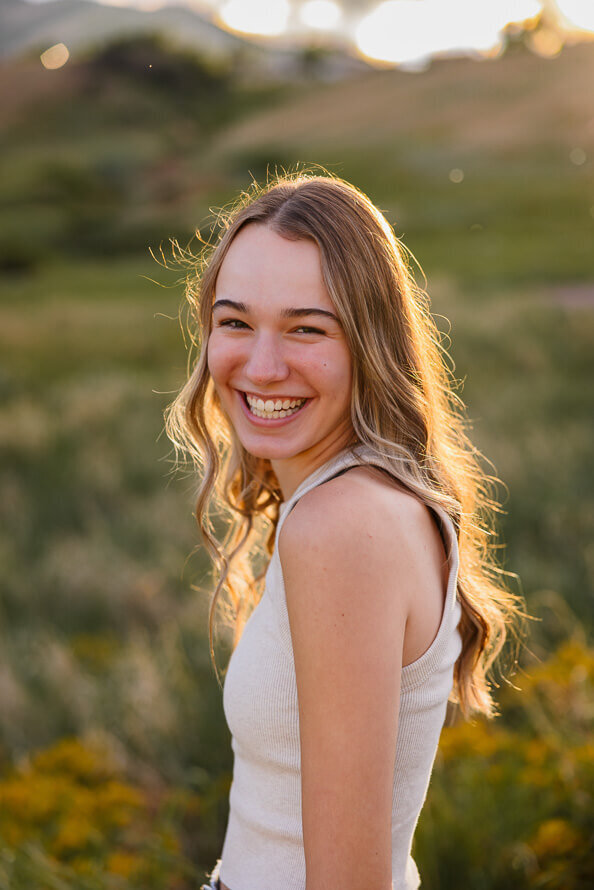 Girl with sun-kissed hair smiles into camera.