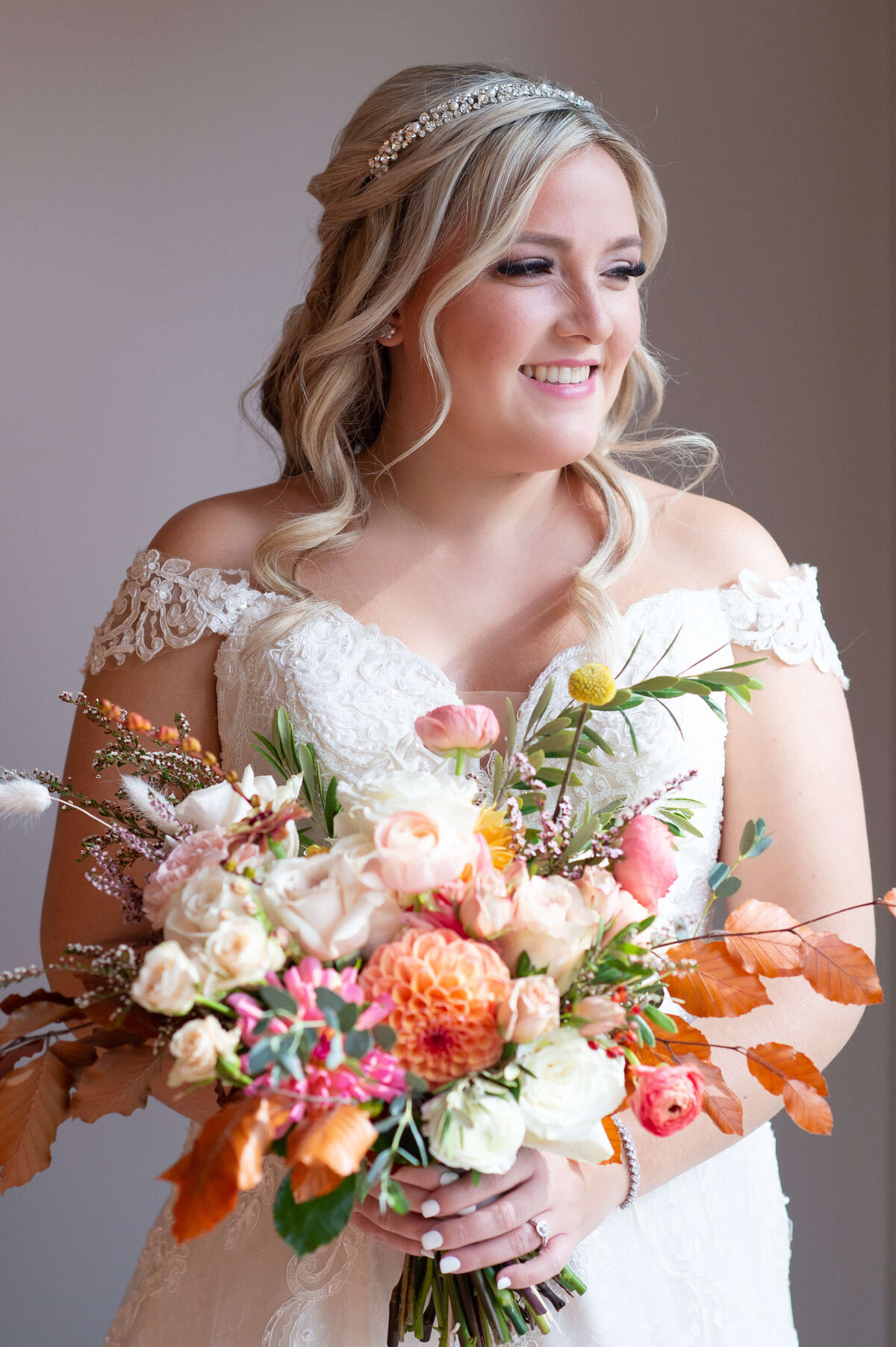 a gorgeous portrait of a bride holding her fall-coloured bouquet taken inside at Strathmere wedding venue.  Captured by Ottawa wedding photographer JEMMAN Photography