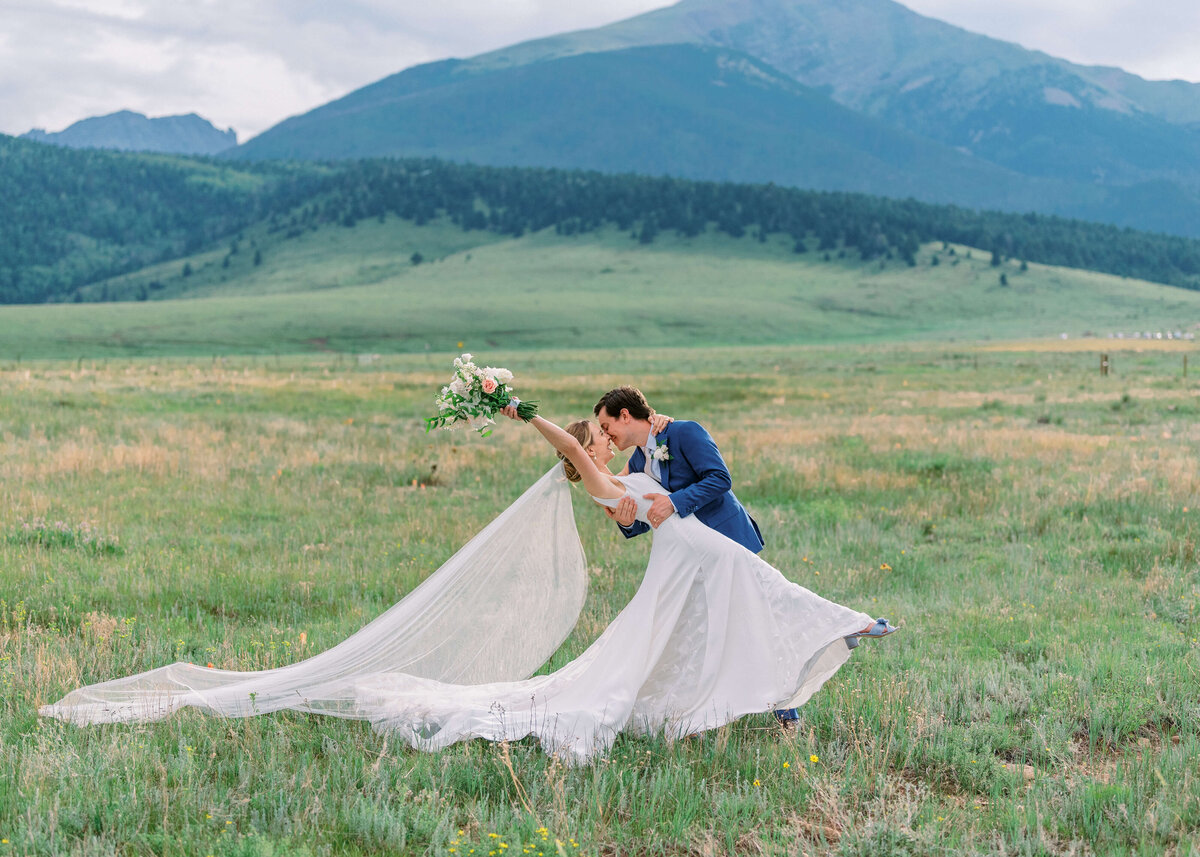 Time to celebrate - this man and woman are married! The groom dips his bride while her veil flies out behind her