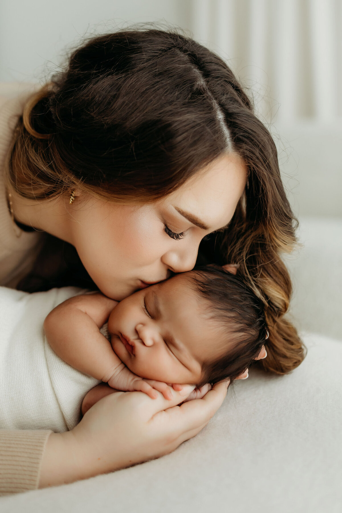 A new Mom snuggles closely to her newborn baby boy, photographed by a Vancouver Washington newborn photographer