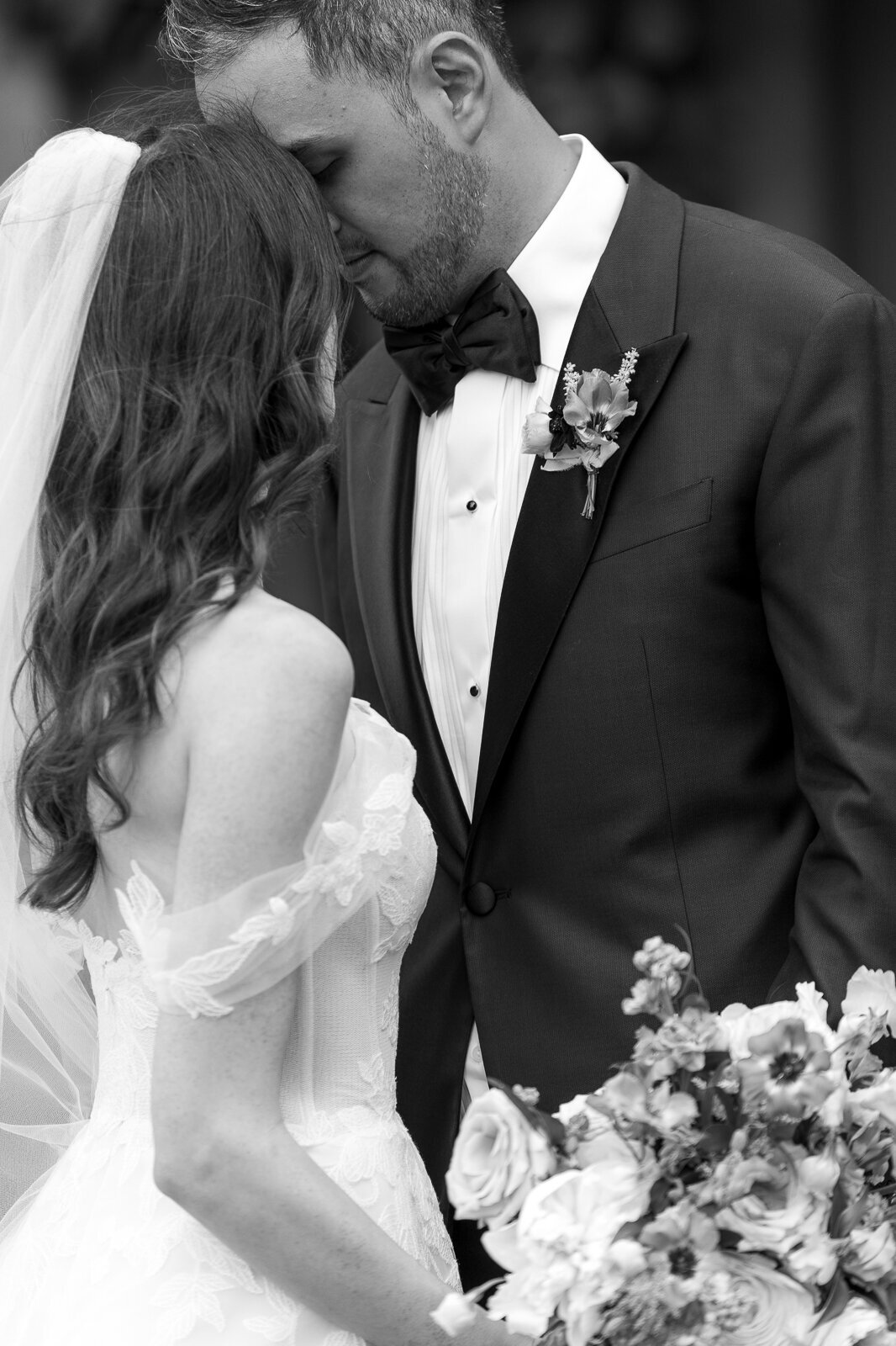 black and white ethereal bride portrait of bride nuzzling groom's neck