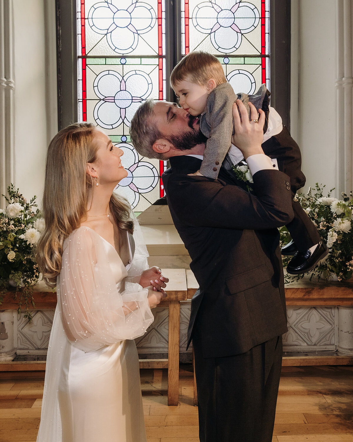 Bride and groom giving a child a kiss at the wedding alter at Smock Alley in Dublin, Ireland