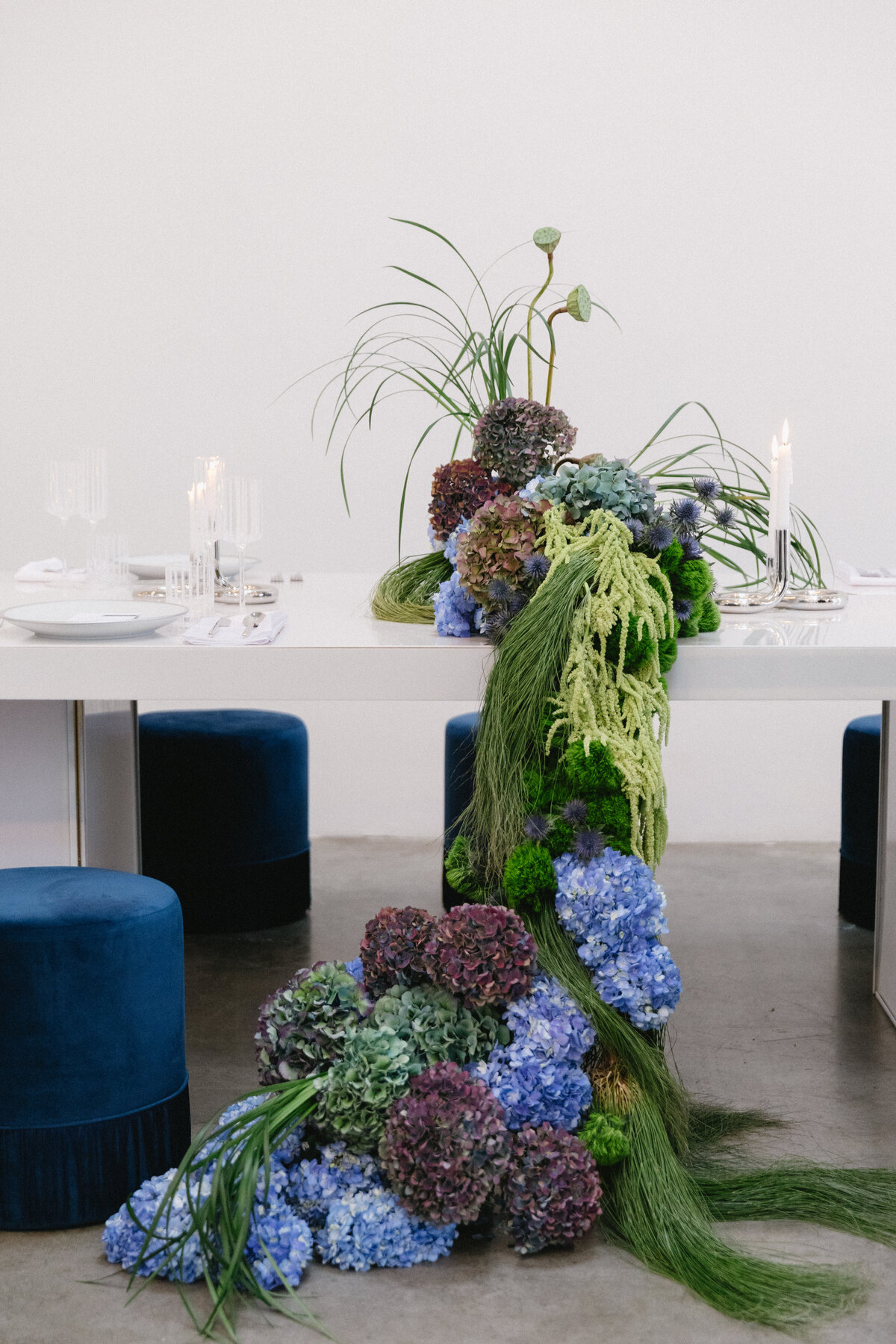 Bride and groom seated closely, holding a sculptural hydrangea bouquet at an editorial New York City wedding shoot.