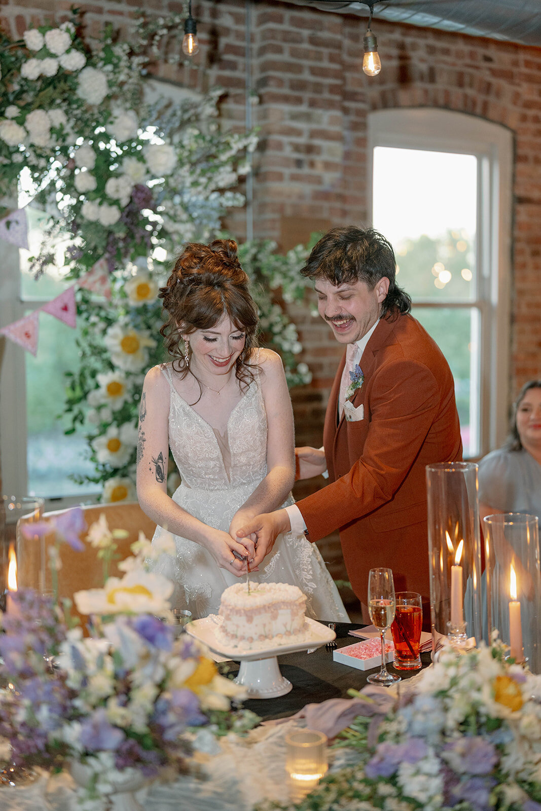 Bride and groom cutting wedding cake at Record Box Loft reception in Battle Creek