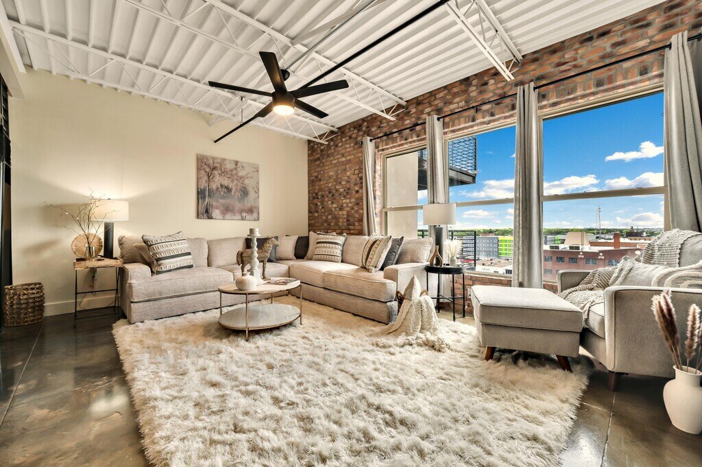 Spacious living room with beautiful downtown views, smart TV and plenty of seating in this 2 bedroom, 2.5 bathroom luxury vacation rental loft condo for 8 guests with incredible downtown views, free parking, free wifi and professional decor in downtown Waco, TX.