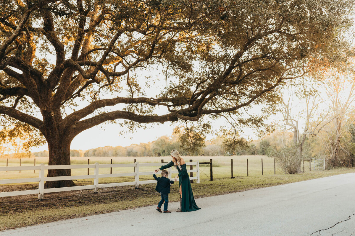 mom spends her son while dancing in the street under a big oak tree