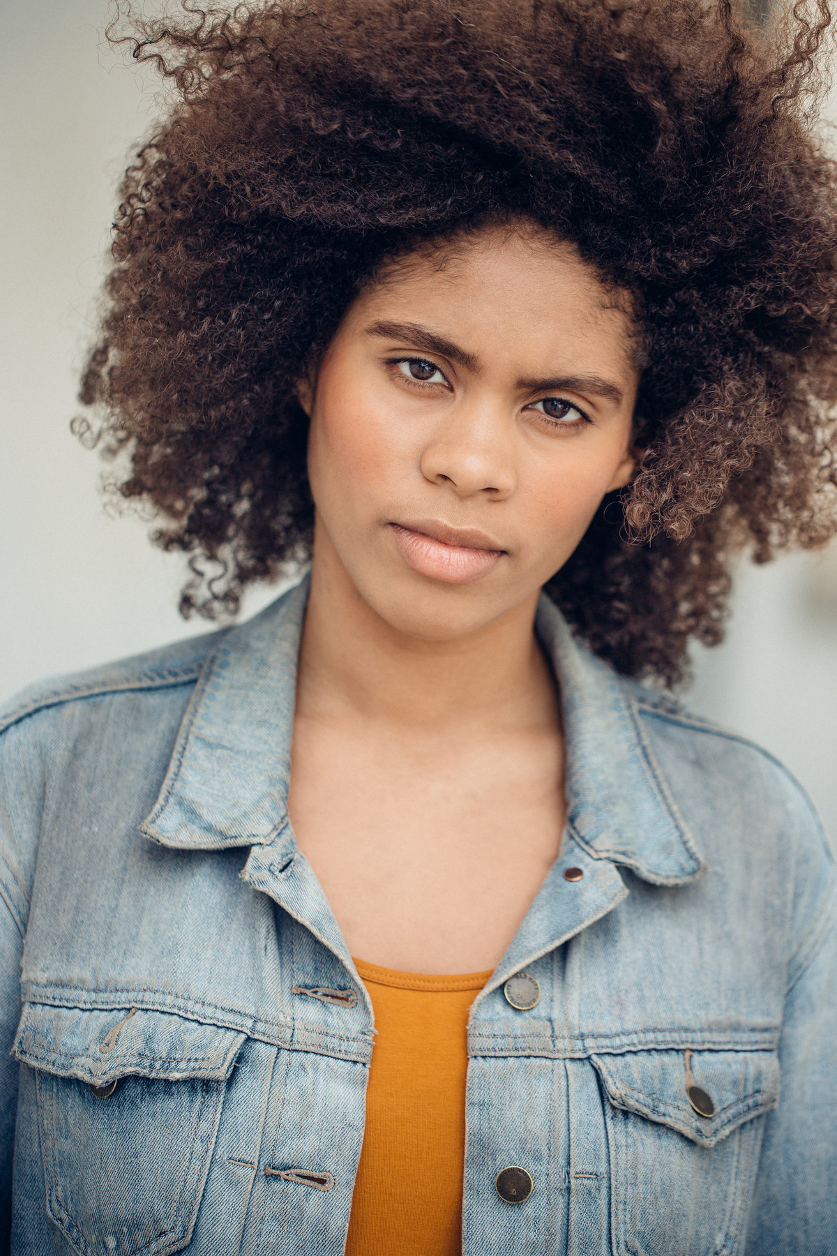 Headshot Photograph Of Young Woman In Outer Gray Denim Jacket And Inner Orange Shirt Los Angeles