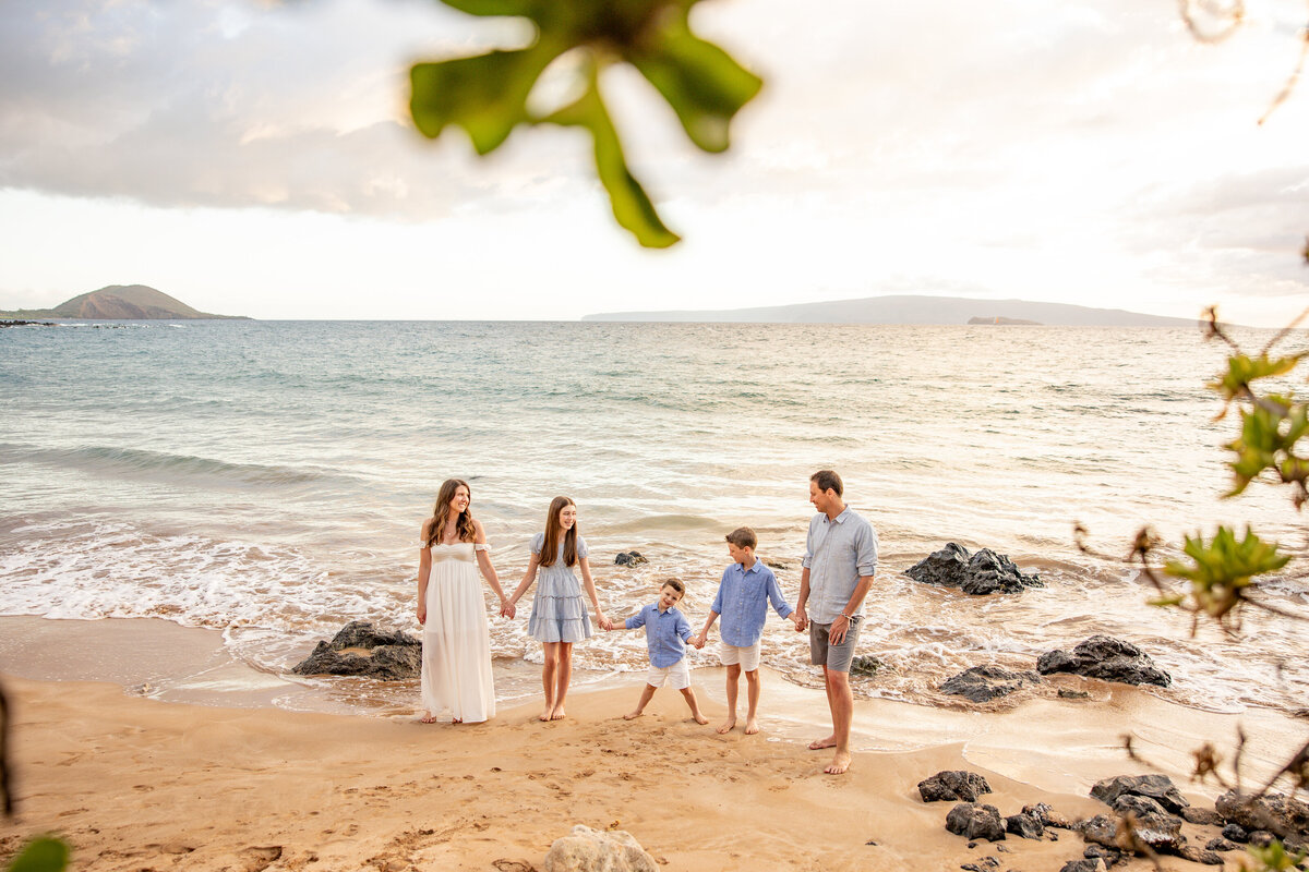 Maui Family Photographers capture family holding hands at. waterside during family beach photos