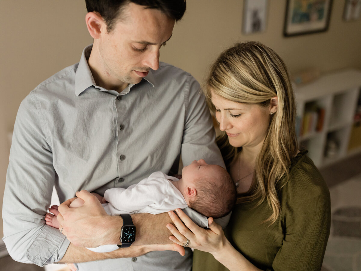 mom and dad holding newborn baby boy for in home photoshoot