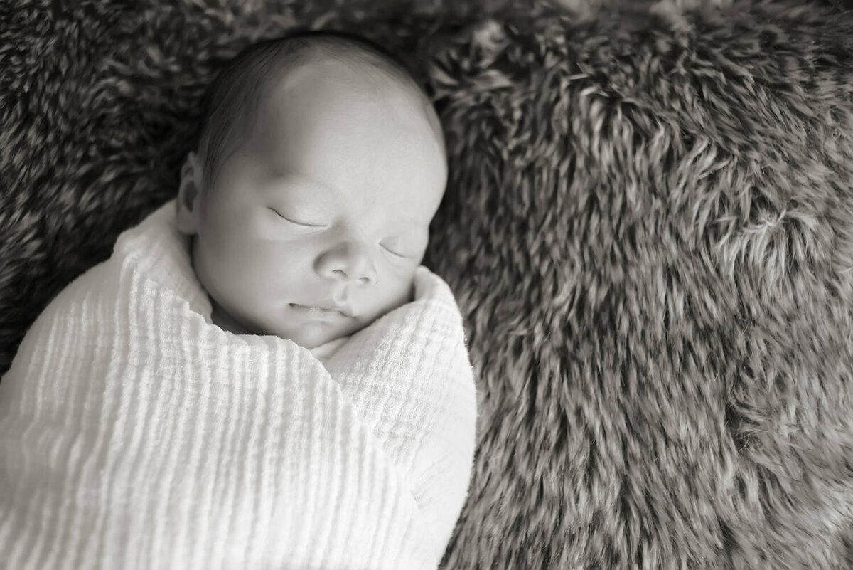 A newborn baby swaddled as they sleep 