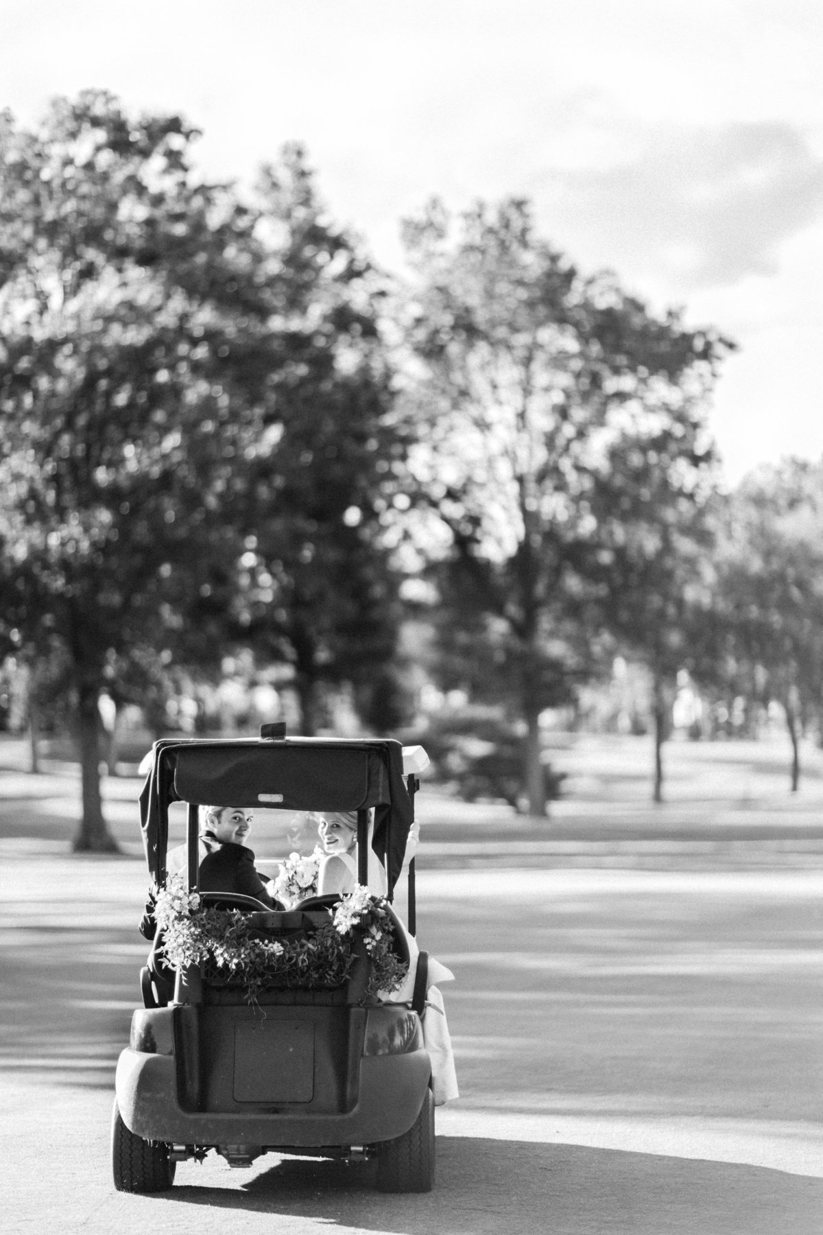 Bride and groom riding golf cart at Hartford Country Club