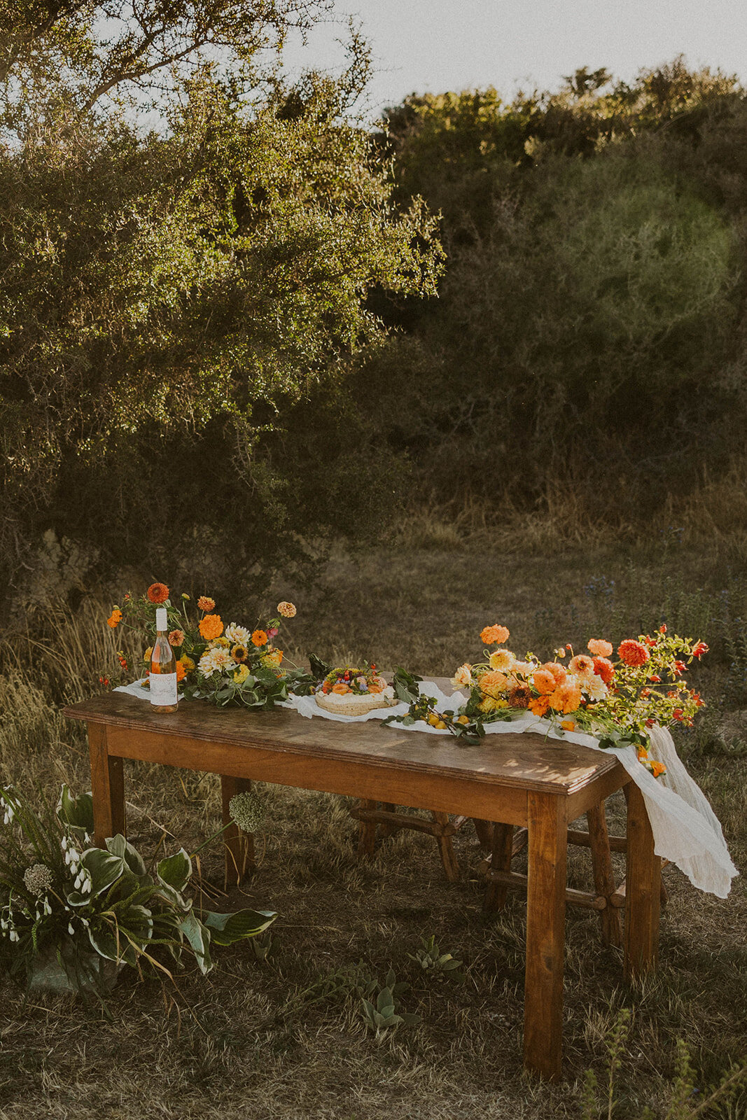 Elopement table setting in the trees at Lake Tekapo with orange coloured table arrangements