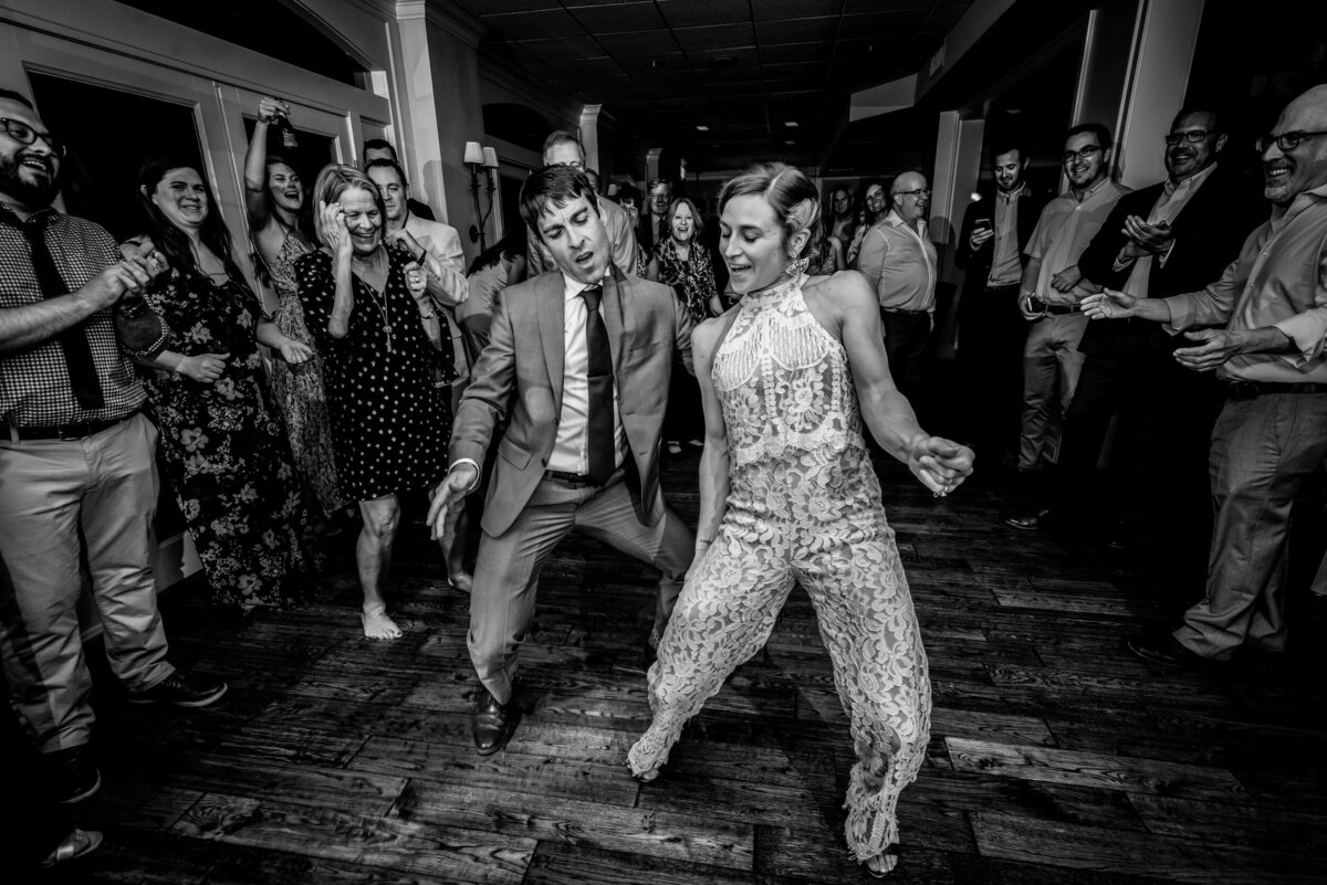 Groom and bride wearing a jumpsuit dance during their wedding