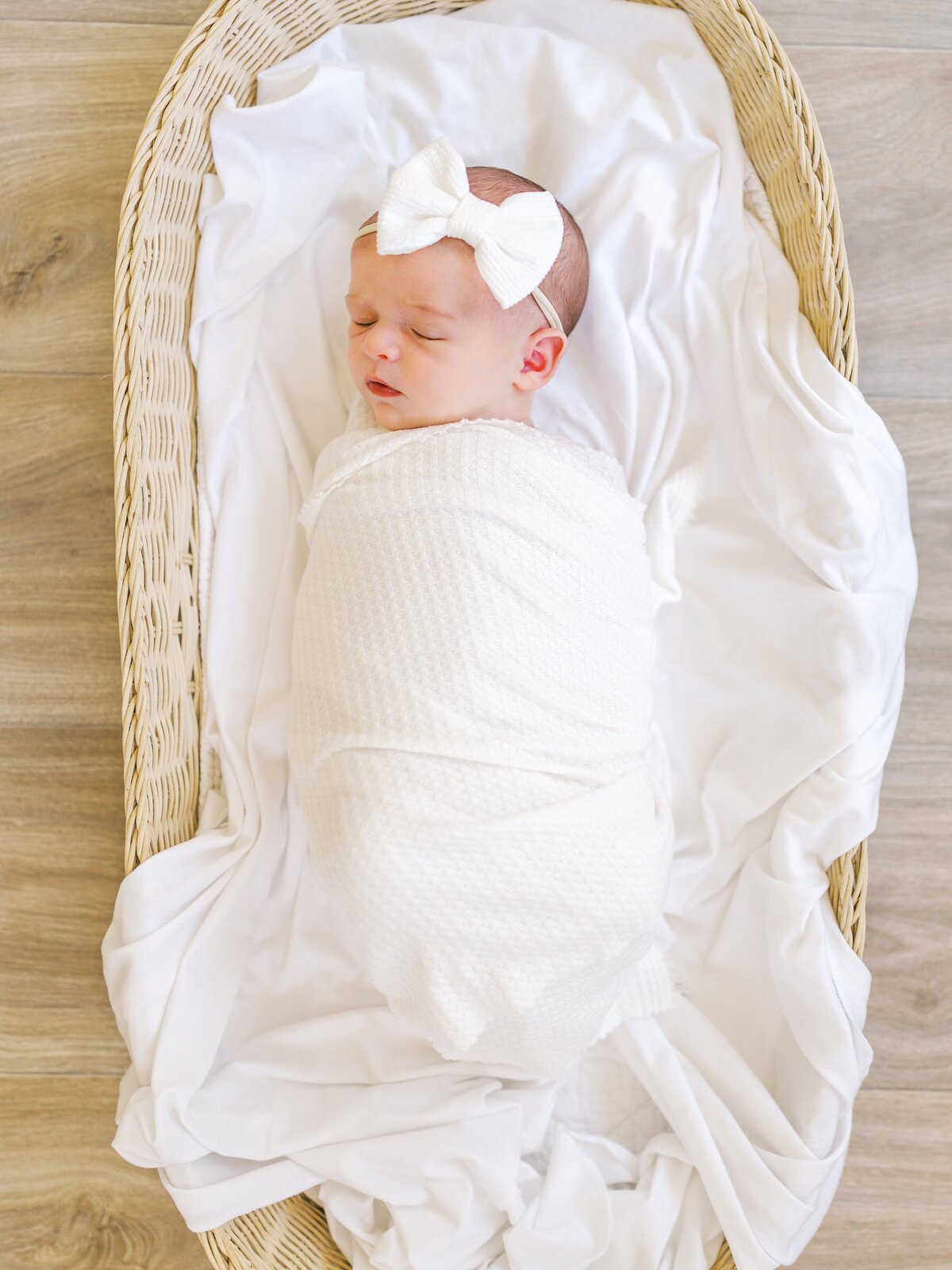 A newborn baby girl laying in basket.