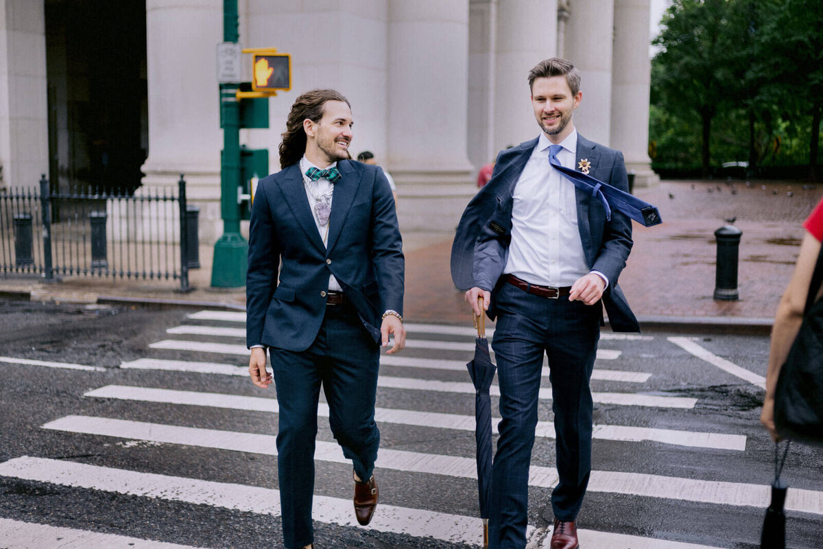 The two grooms are crossing the street. NYC City Hall Elopement Image by Jenny Fu Studio