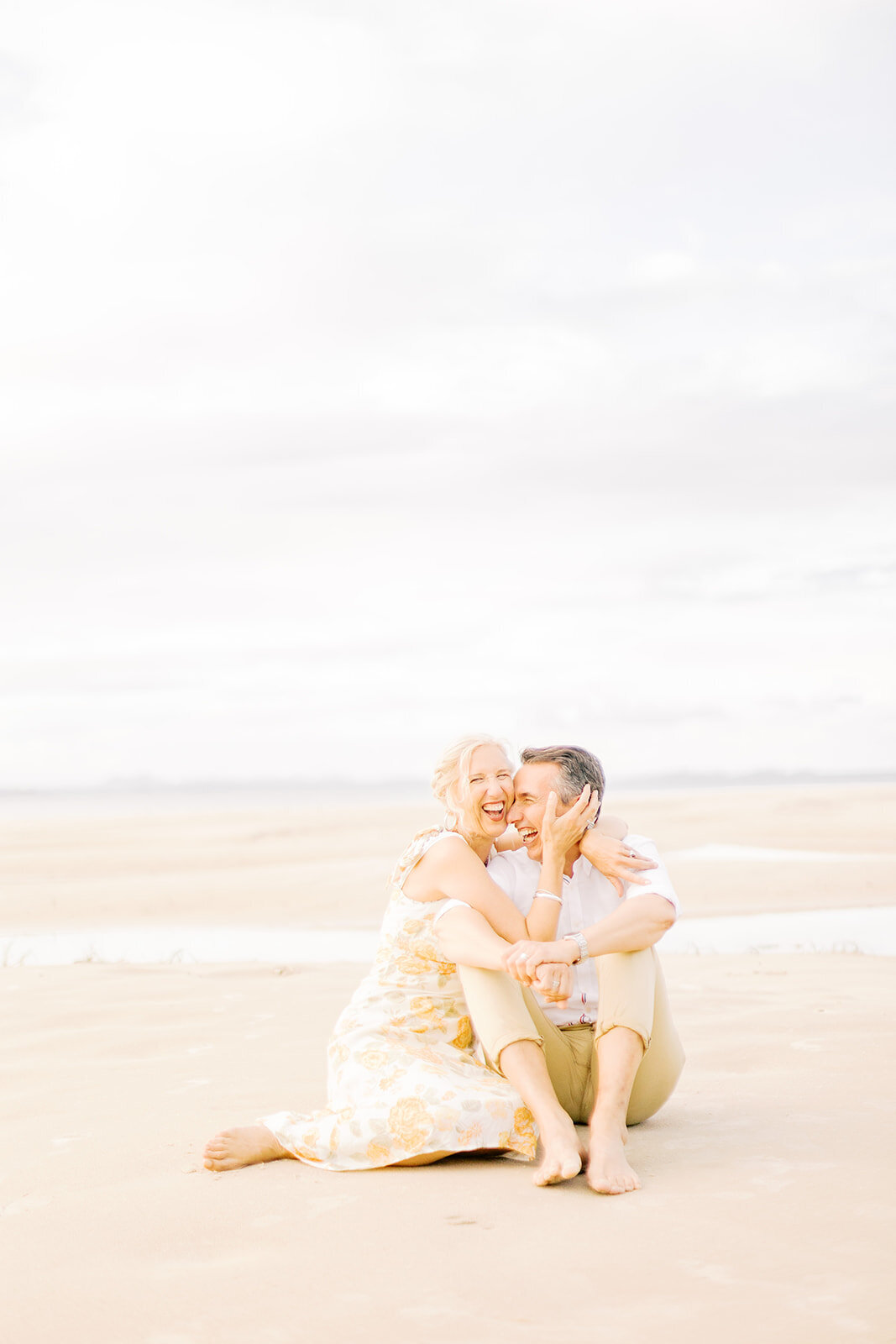 wife laughing with husband on beach