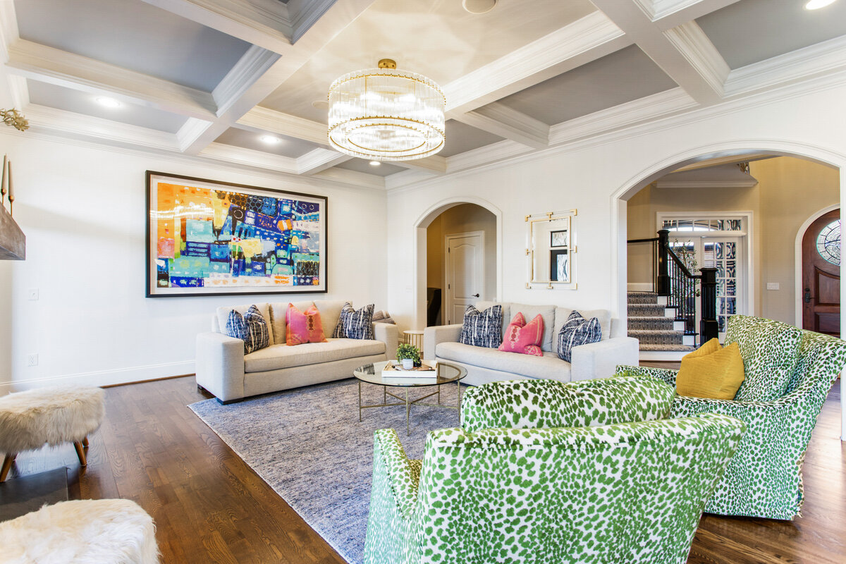 living room with white furniture and various colorful accent pieces and green chairs