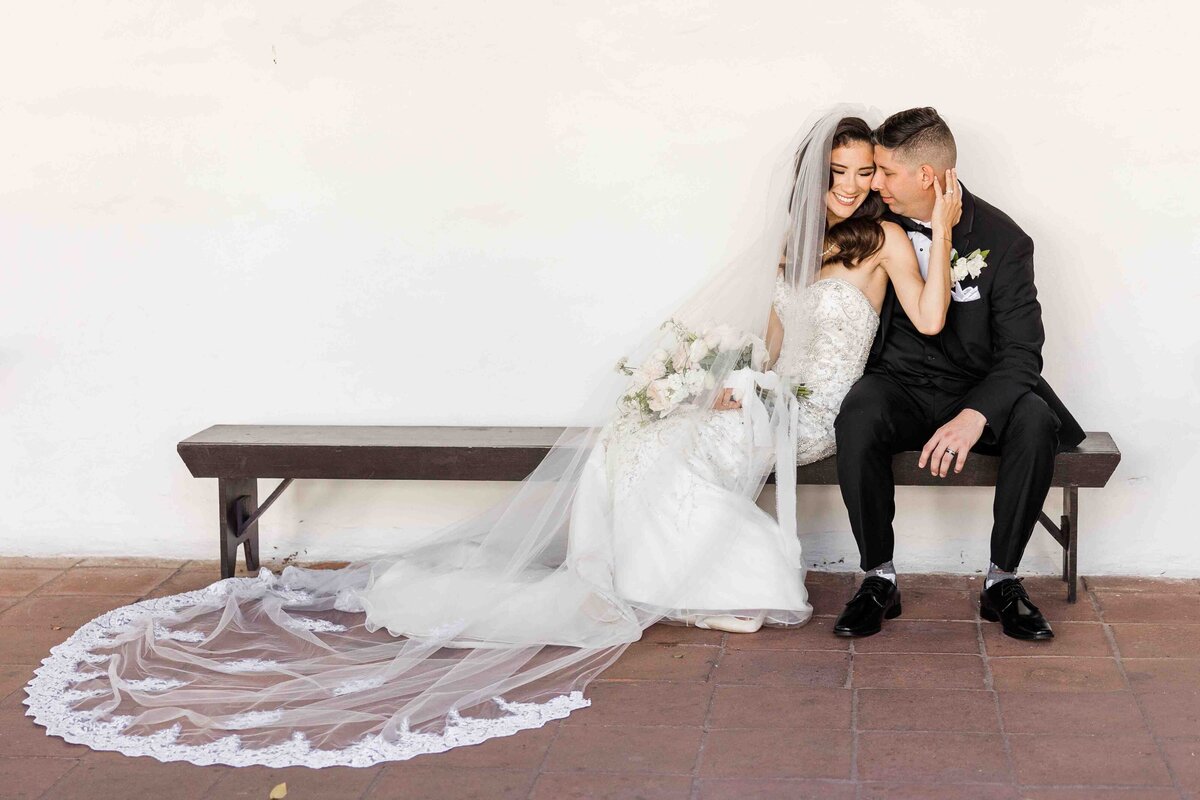 bride-and-groom-sititng-san-diego-mission-courtyard