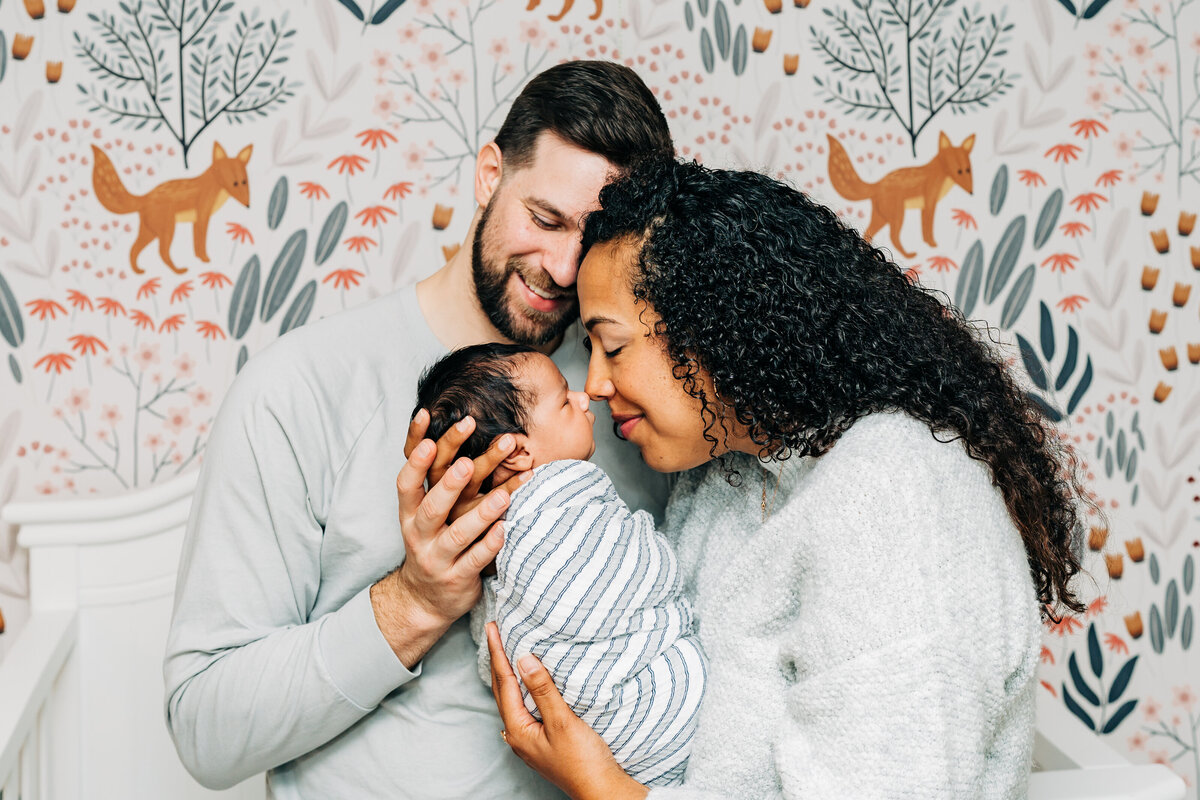 newborn-family-portrait-wrapped-baby-parents-kiss