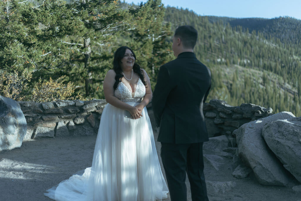 A person smiling at their partner while in a wedding dress.