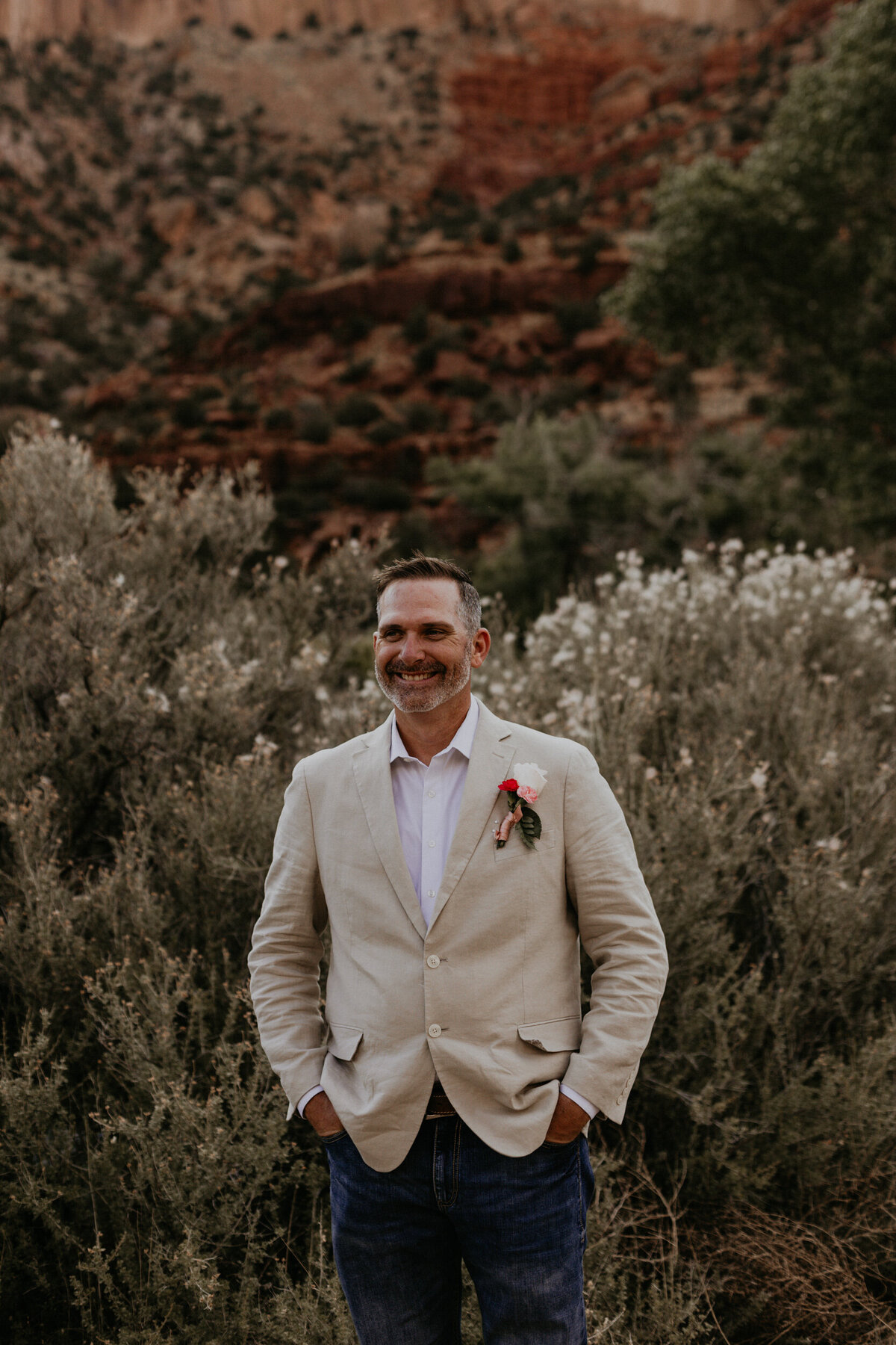 groom smiling in his tan blazer an jeans