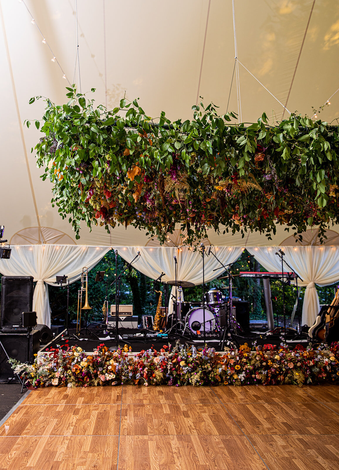 An oversized square hanging flower installation over the dance floor is a great alternative to a floral chandelier! Lush smilax vines, hops, copper beech, and bright wildflowers. RT Lodge and Nashville wedding floral designer.
