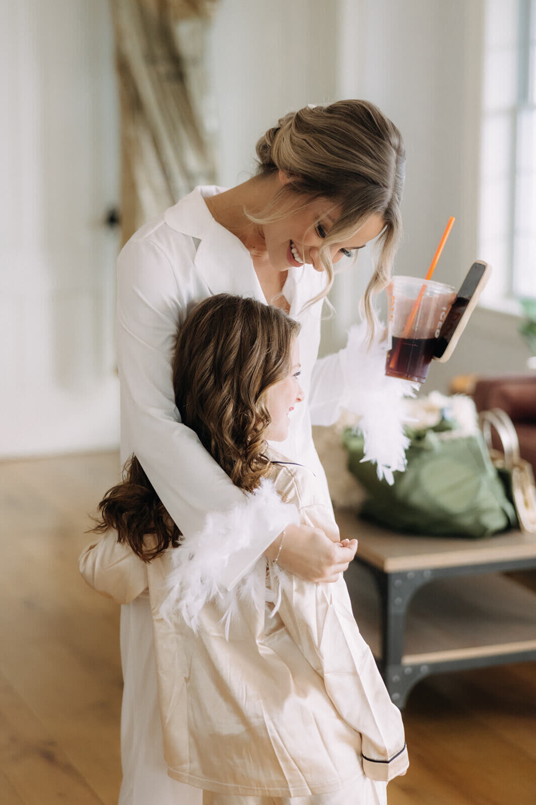 Bride cuddling young girl before wedding at Finger Lakes