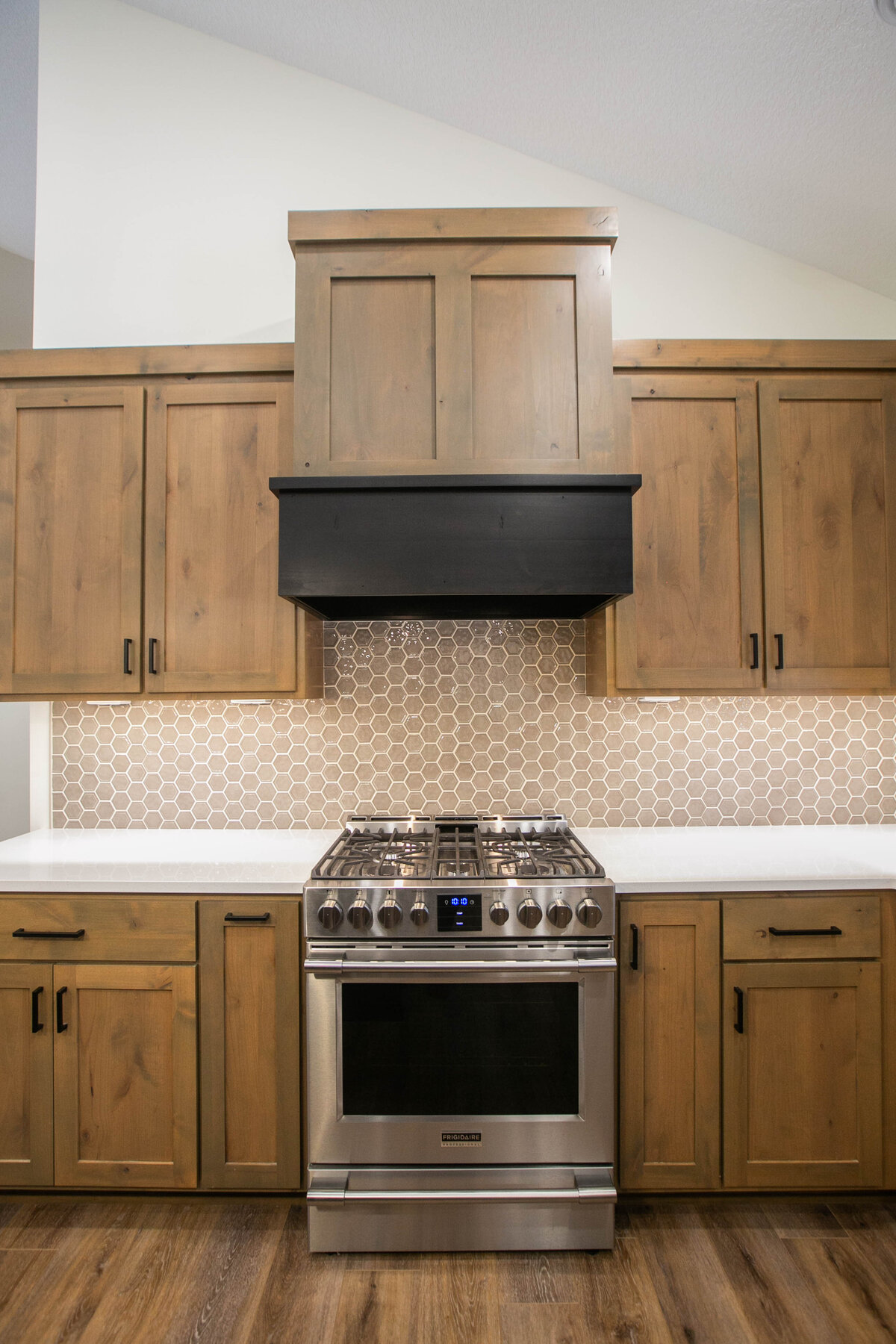 Open kitchen with dark cabinets, large island, and quartz countertops in an Elk River custom home