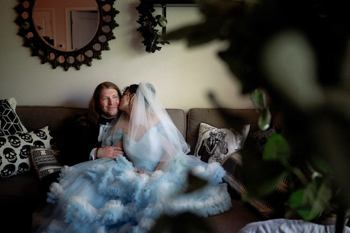 Bride kisses groom's cheek at their cozy home in columbus