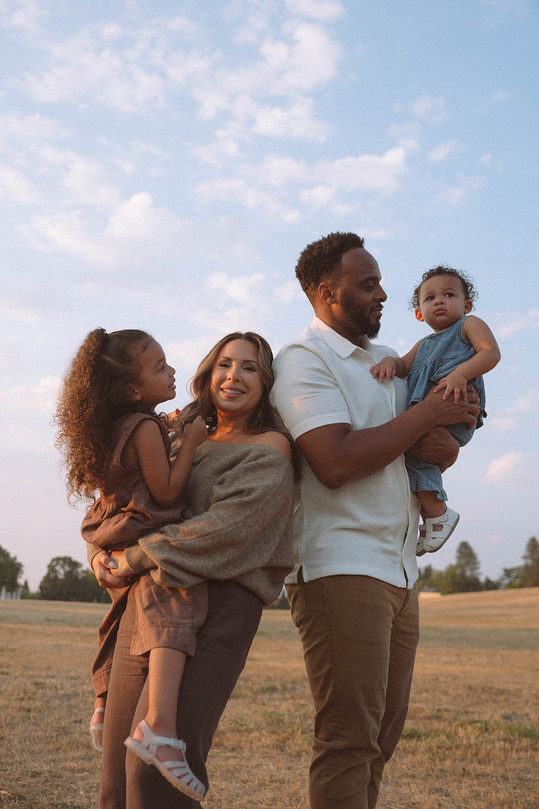Parents smiling with their children in an outdoor family photography session in Orange County.