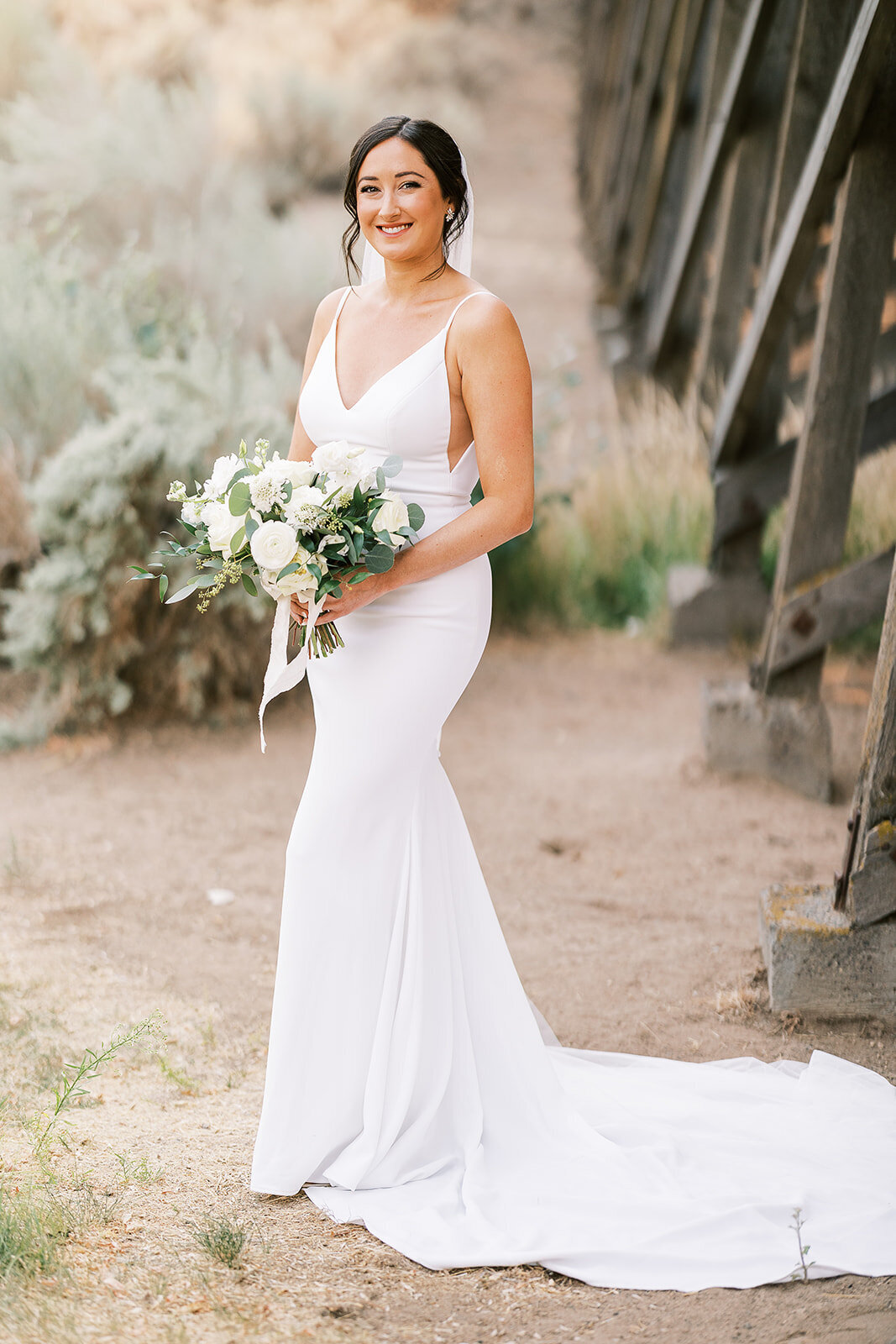 Bride with white bridal bouquet near the trestle bridge at Brasada Ranch