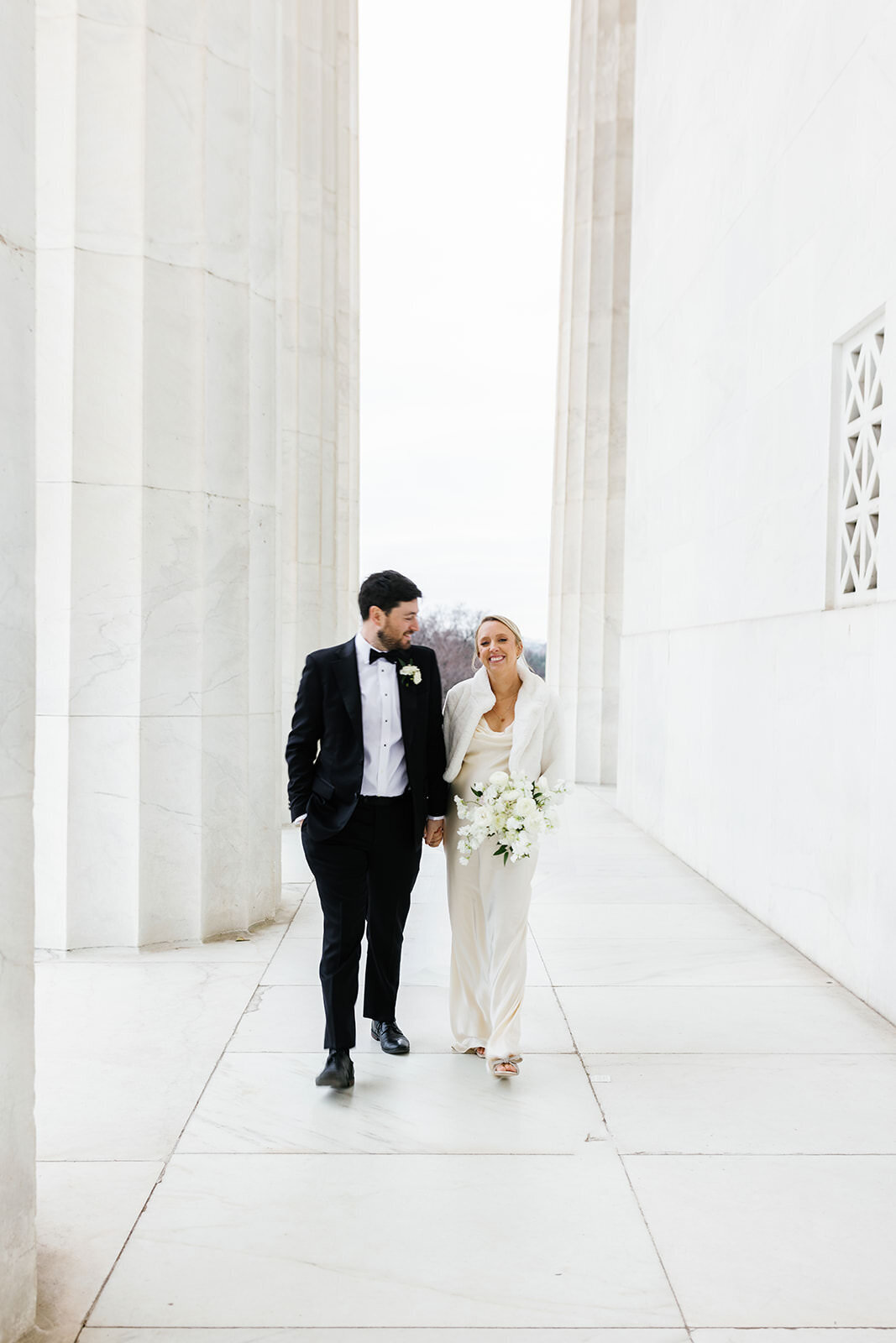 Bride and groom walk hand in hand in DC