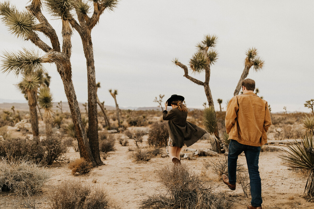 Man and woman walking away from camera in desert